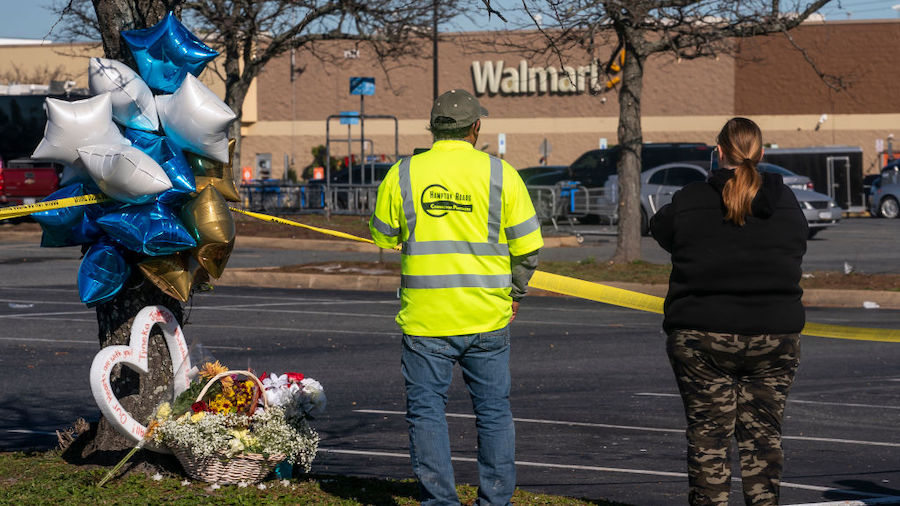Onlookers watch as law enforcement investigates the site of a fatal shooting in a Walmart on Novemb...