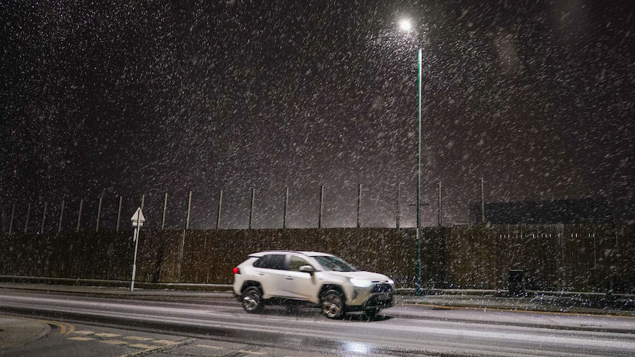 Motorists drive through a heavy snow shower as it passes over Saltburn By The Sea as Storm Arwen sw...