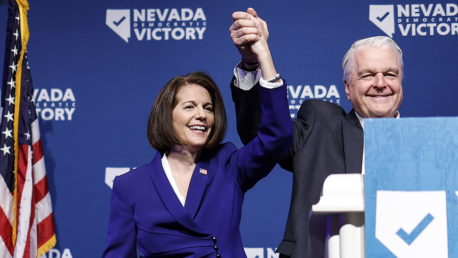 U.S. Sen. Catherine Cortez Masto and Nevada Gov. Steve Sisolak hold their hands up together....