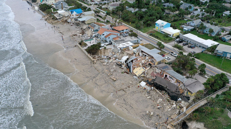 In this aerial view, homes are partially toppled onto the beach after Hurricane Nicole came ashore ...