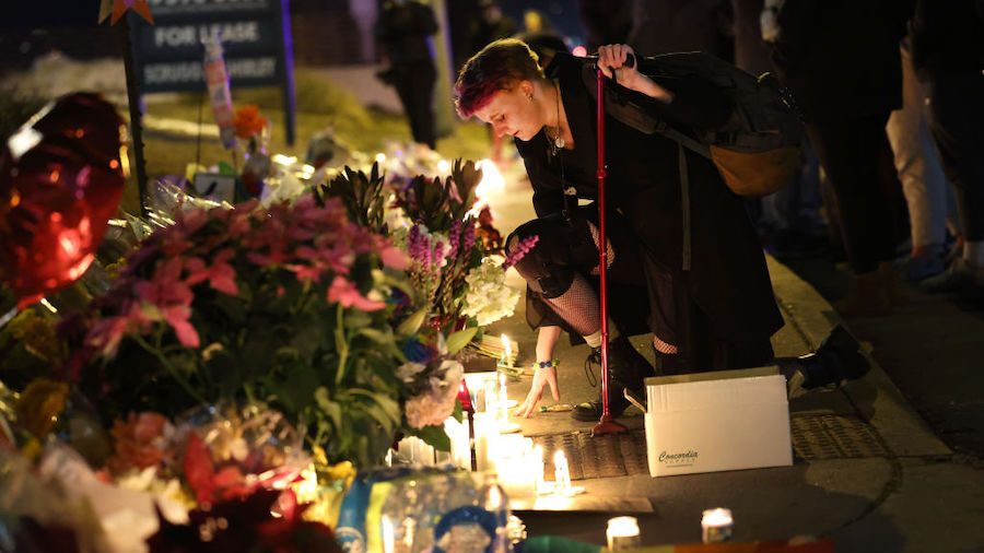 People hold a vigil at a makeshift memorial near the Club Q nightclub on November 20, 2022 in Color...