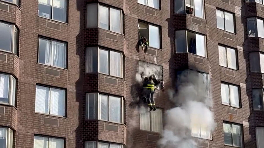 Firefighters rescued a woman dangling from an apartment building in Manhattan where dozens were inj...