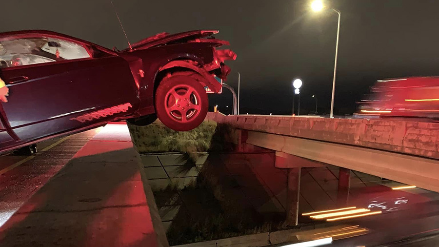 A car hung over a concrete barrier after crashing into it....