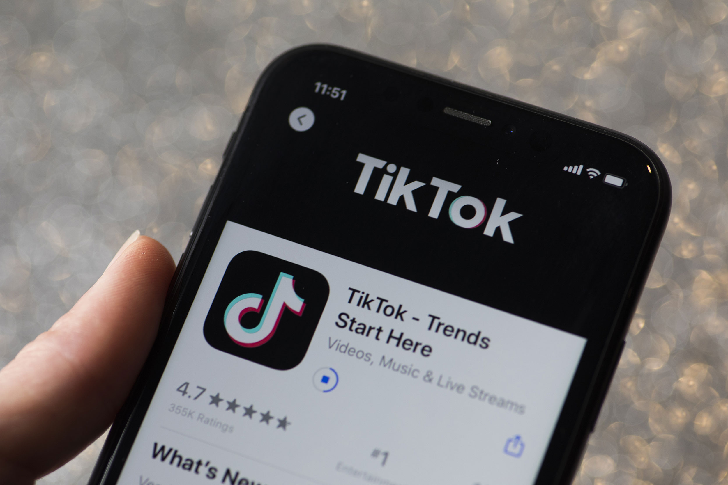 The download page for ByteDance Ltd.'s TikTok app is arranged for a photograph on a smartphone in S...