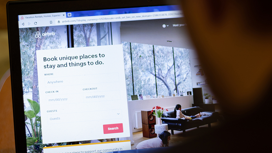 New York, USA - 9 April 2020: Airbnb website on laptop screen close up. Man using service on displa...