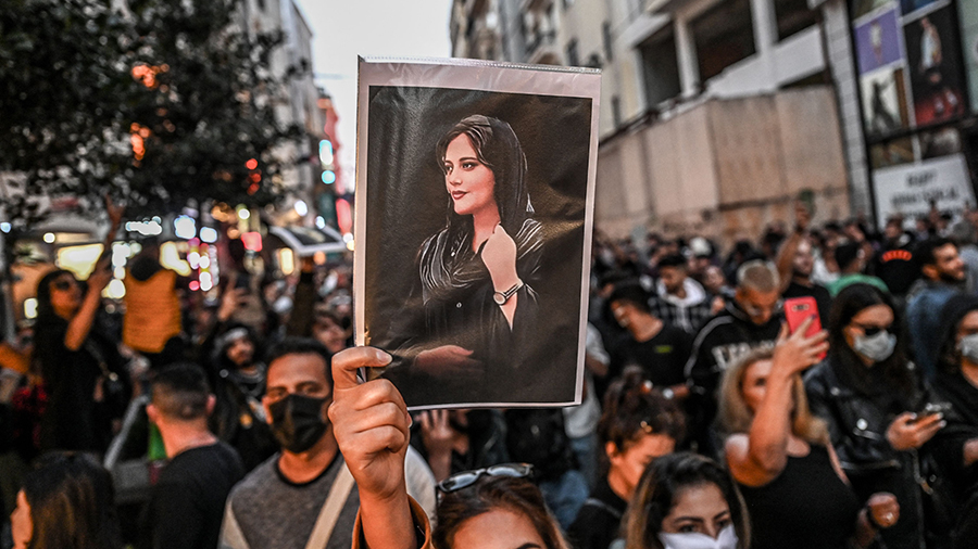 TOPSHOT - A protester holds a portrait of Mahsa Amini  during a demonstration in support of Amini, ...