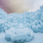 Ice in mounds showing layers of light blue ice and snow. (Ice Castles)