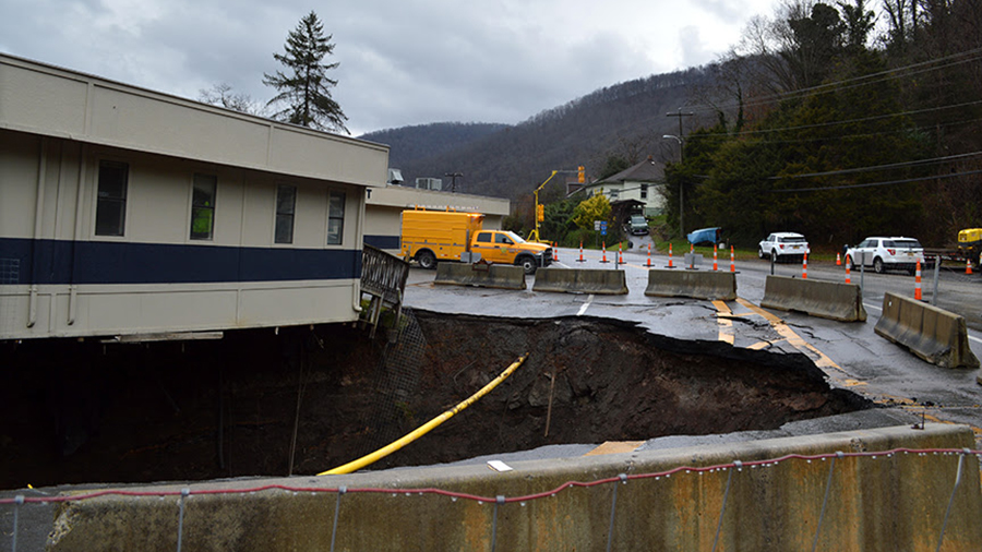 A massive sinkhole is seen leaving parts of the police department building hanging over the edge....