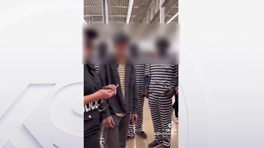 This is a frame from the video that shows three teens dressed prisoner clothing and with blackface....