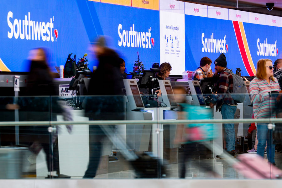 Travelers walk past the Southwest Airlines check-in counter at Denver International Airport on Dece...