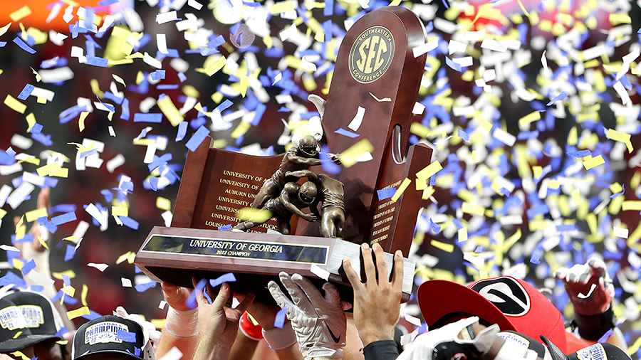 tetson Bennett #13 of the Georgia Bulldogs celebrates with the trophy...
