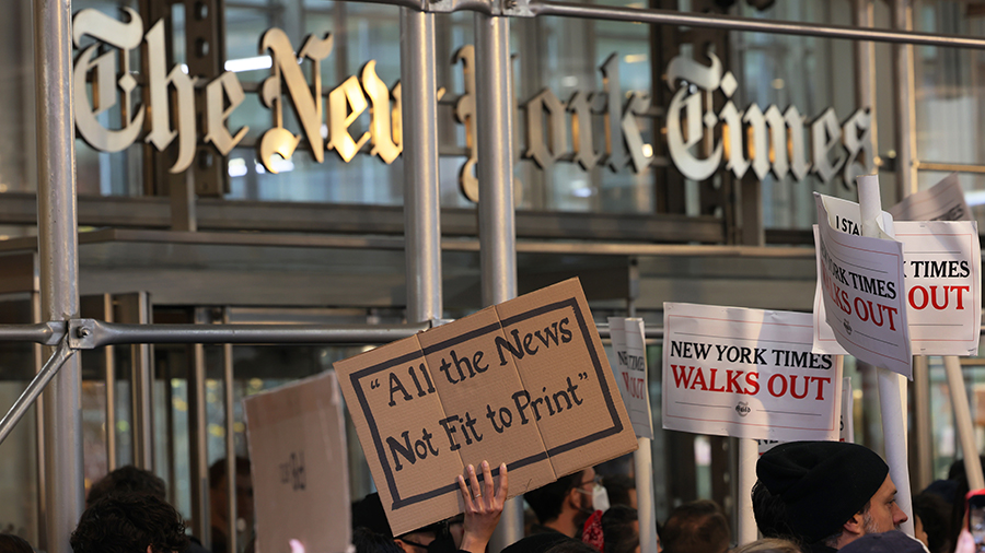 People holding signs outside of the New York Times....