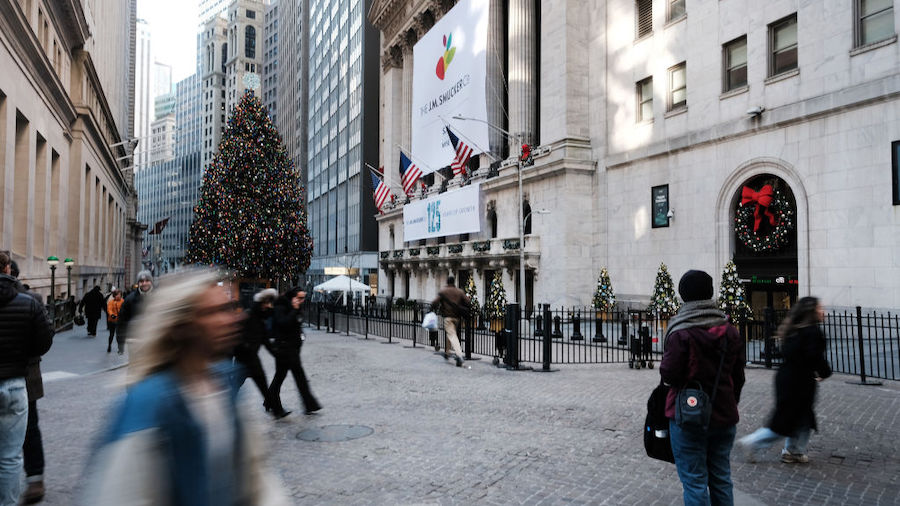 People walk by New York Stock Exchange (NYSE) on December 13, 2022 in New York City. In a sign that...