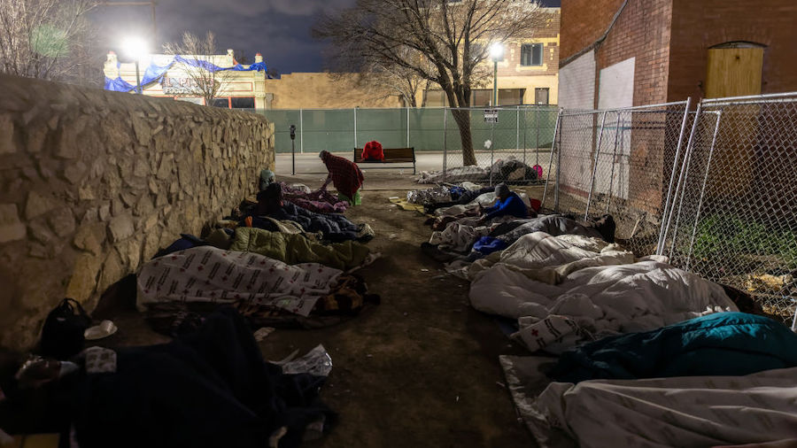 Immigrants sleep in the cold outside a bus station on December 18, 2022 in El Paso, Texas. On Satur...