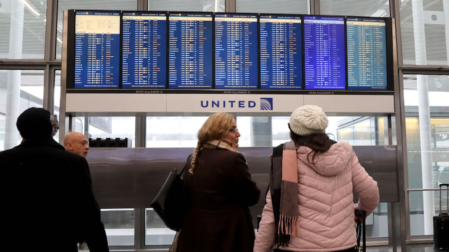 Travelers check the status of their flights at O'Hare International Airport in Chicago, Illinois. A...