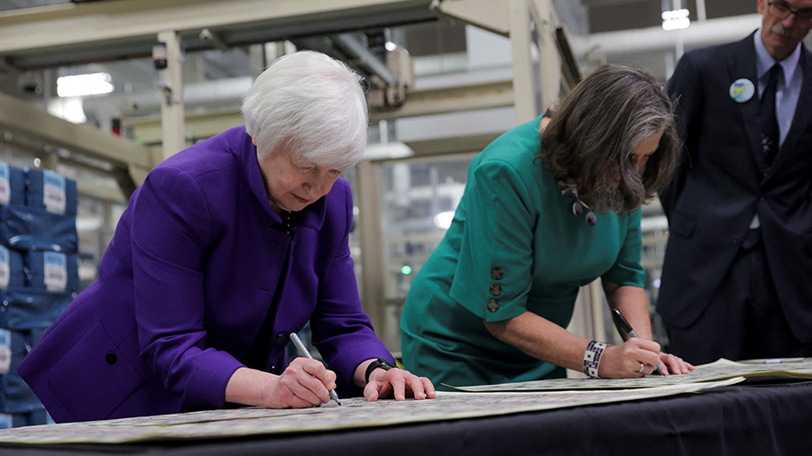 Two women are signing banknotes....