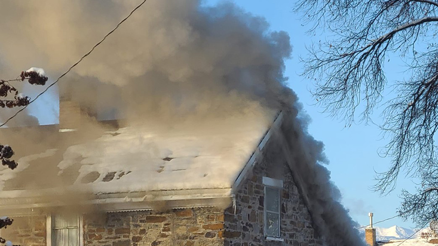 old rock home has smoke coming out of the attic...