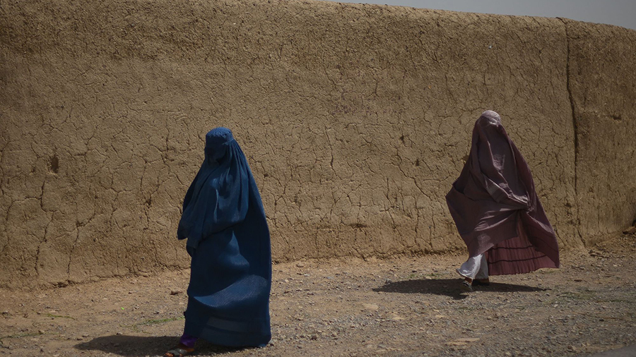 Afghan women walk alongside a road in Kandahar on July 29, 2022. (Photo by Daniel LEAL / AFP)...