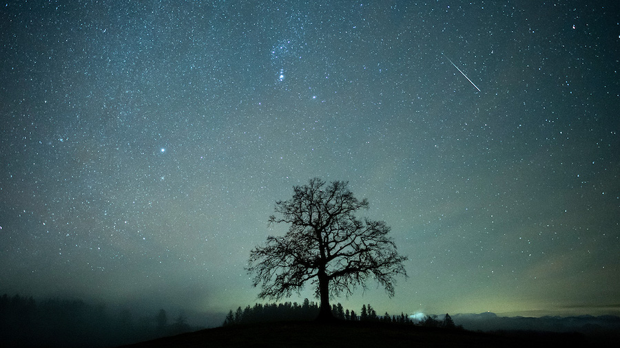A bright meteor can be seen during the Geminids shower on December 14, 2020, in Bavaria, Germany. K...