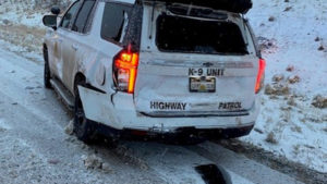 A UHP SUV is on the side of the road with damage.