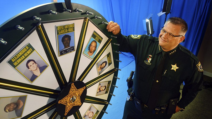 FILE - Brevard County Sheriff Wayne Ivey gets ready to spin his popular "Wheel of Fugitive" in July...