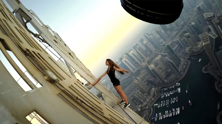 woman leans off skyscraper for video content...