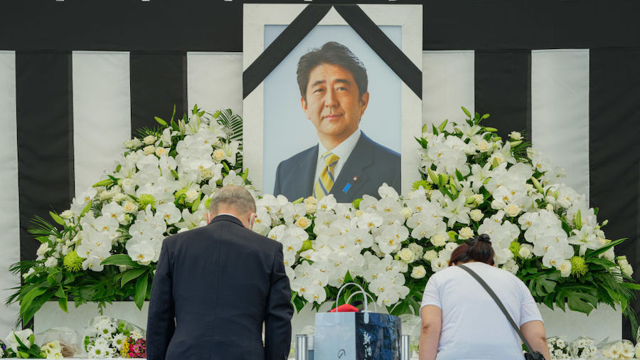 People leave flowers and pay their respects outside the Nippon Budokan during the state funeral for...
