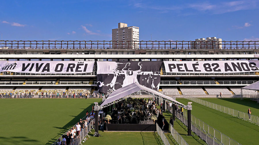Flags remembering Pelé are displayed on the stands as mourners queue inside Vila Belmiro stadium t...