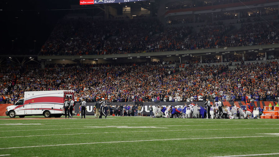 Fans look on as the ambulance leaves carrying Damar Hamlin #3 of the Buffalo Bills after he collaps...