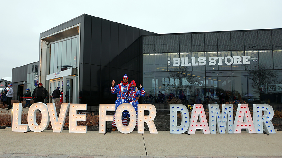 Fans pose with a sign erected in front of the stadium for Damar Hamlin #3 prior to the game between...