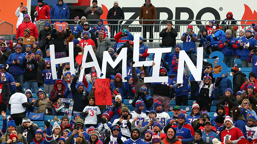 Buffalo Bills fans hold signs in support of Buffalo Bills safety Damar Hamlin prior to the game aga...