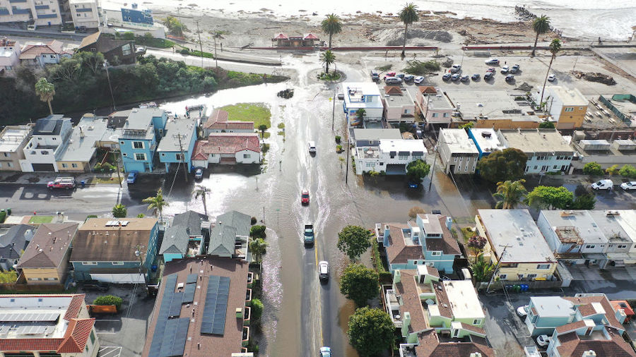 In an aerial view, vehicles drive along a flooded street close to the beach on January 10, 2022 in ...