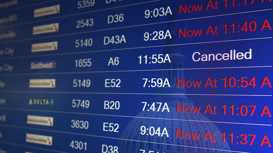 Flight delays are shown on a flight information board at Ronald Reagan Washington National Airport ...