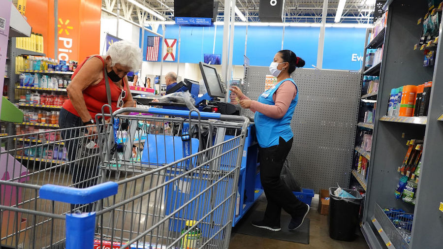 A worker rings up a customer at a cash register in a Walmart store on January 24, 2023 in Miami, Fl...