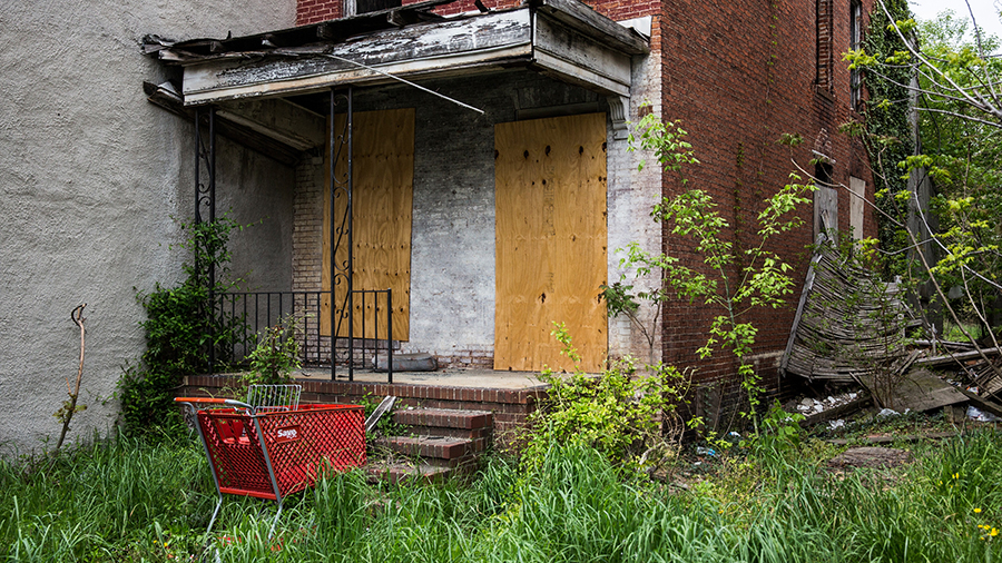 A shopping cart sits abandoned in front of a derelict building in the Sandtown neighborhood in Balt...
