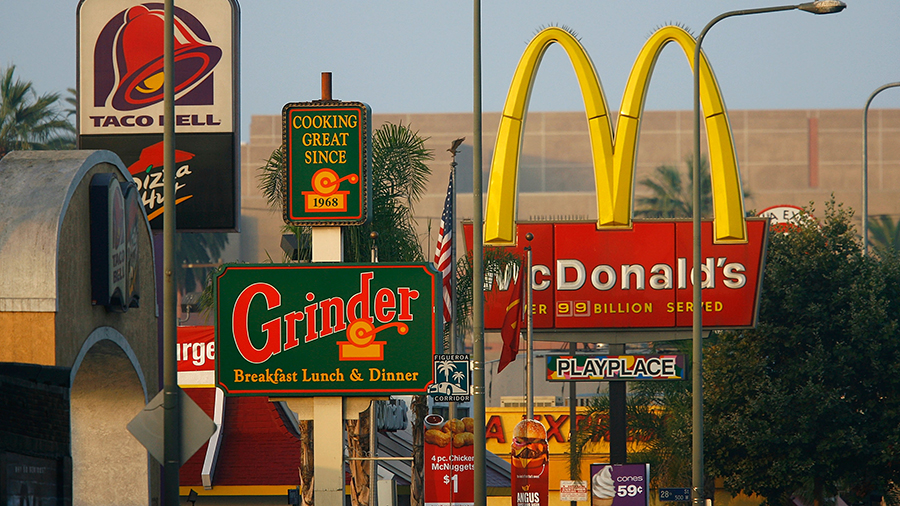 Signs for Taco Bell, Grinder, McDonalds, Panda Express fast-food restaurant line the streets in the...