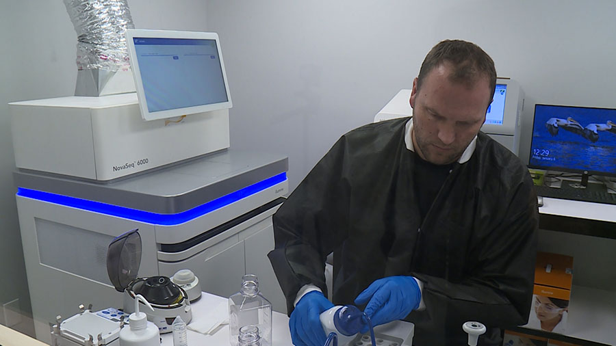 Intermountain Forensics worker using one of the DNA machines. (KSL-TV)...
