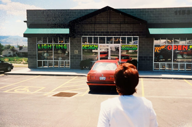 Outside of Eyre Electric showing the back of a woman's head and car parked in front