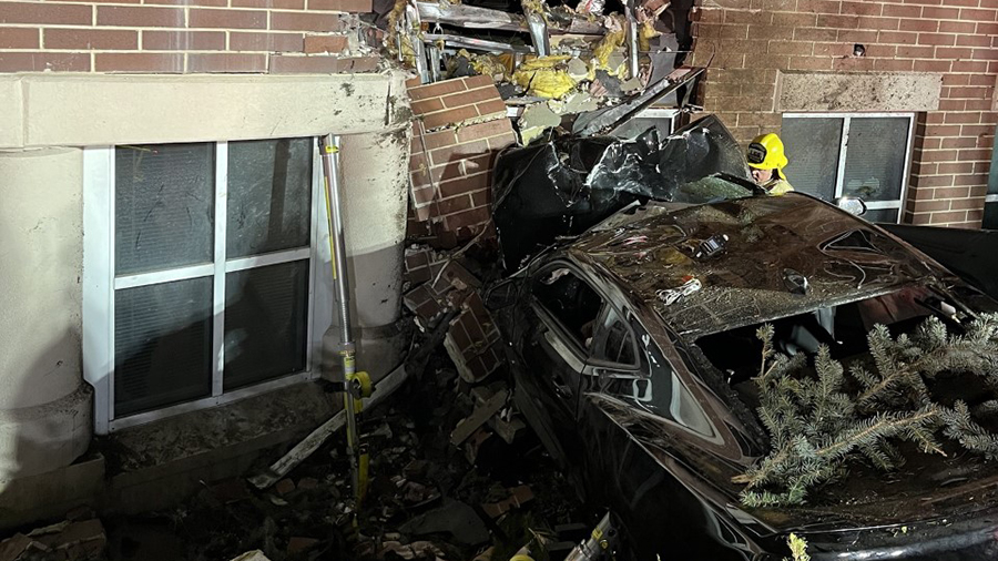 a car is severely damaged against a brick wall...