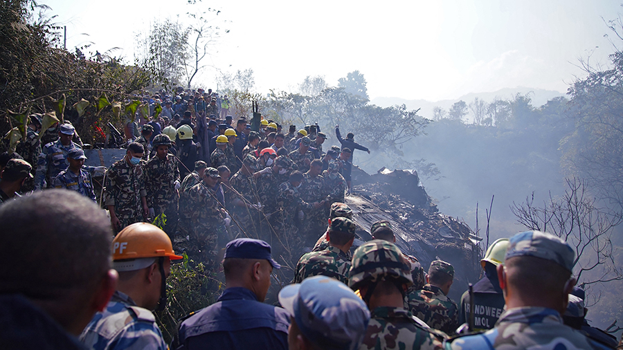 Rescuers gather at the site of a plane crash in Pokhara on January 15, 2023. - An aircraft with 72 ...