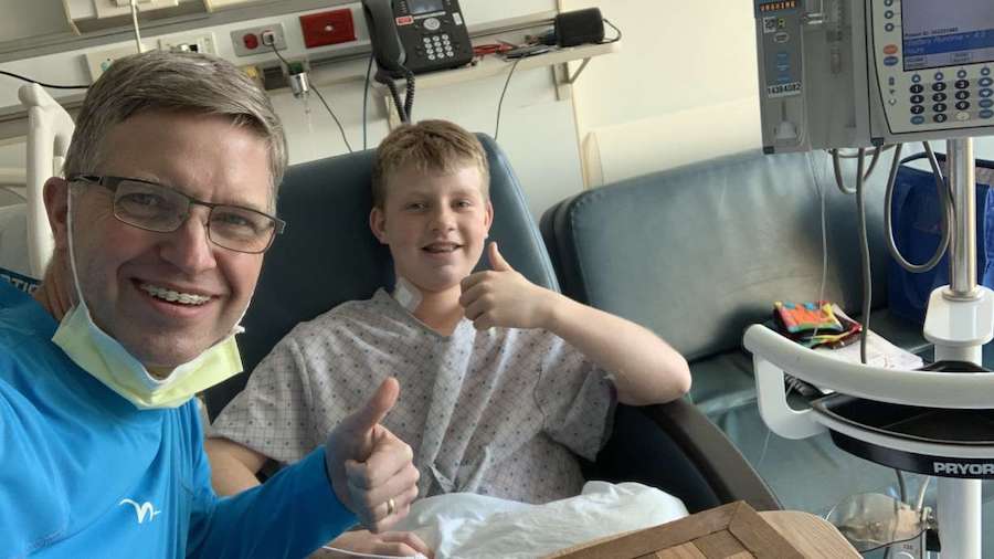 Wilson McConkie, left, visits his 13-year-old son Christian in the hospital. Christian went into ca...