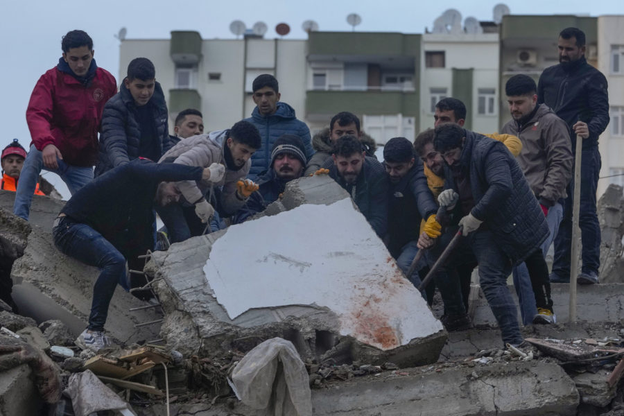 Men search for people among the debris in a destroyed building in Adana, Turkey, Monday, Feb. 6, 20...