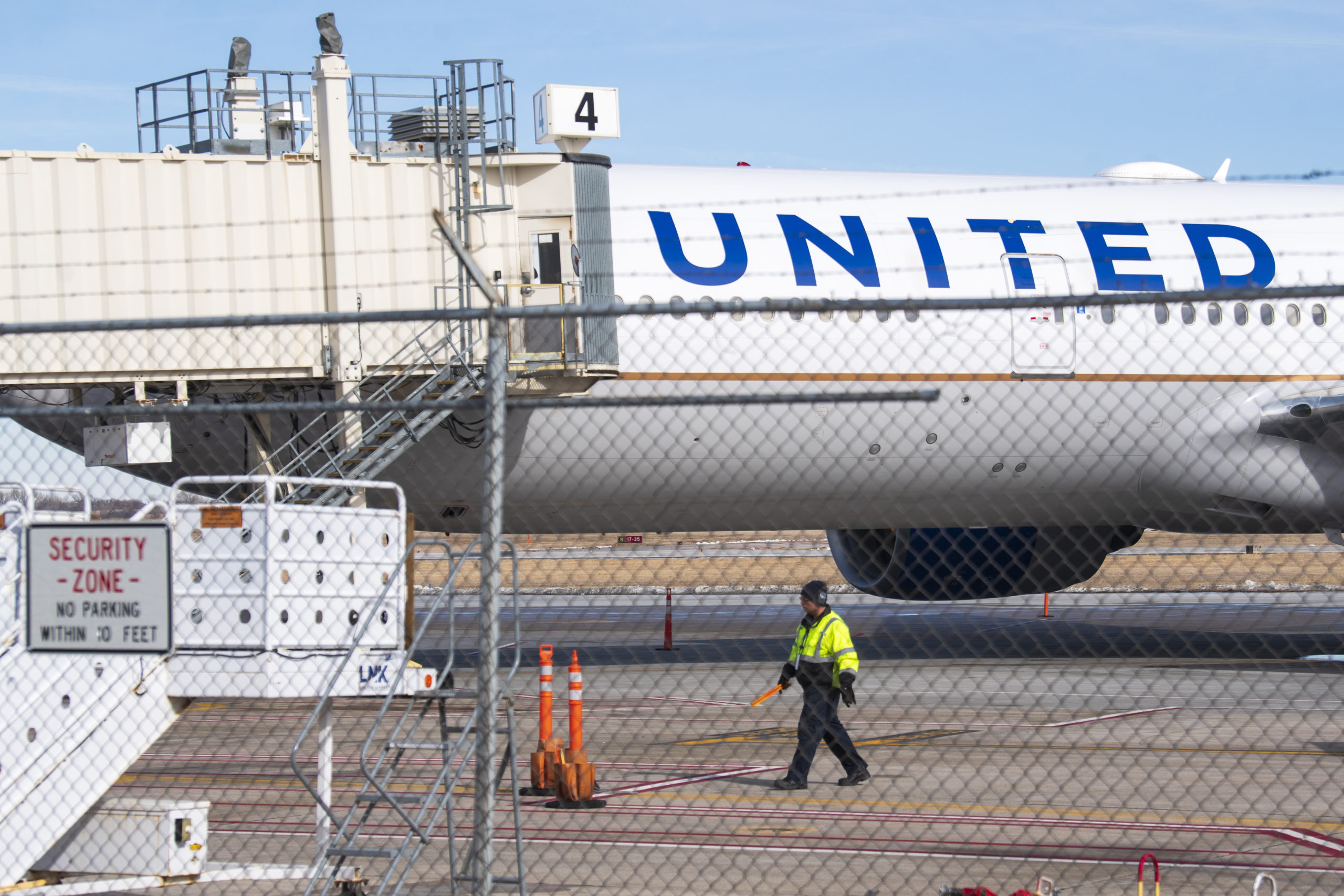 Members of the ground crew secure the site after a United airlines flight made an emergency landing...