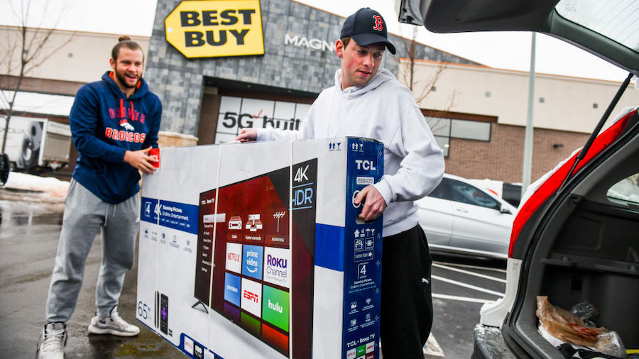 FILE: Brothers Cody Dunham, left, and William Dunham load a television into their car after Best Bu...