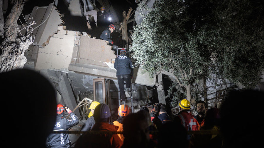 Emergency services workers search a collapsed building for the bodies of three people killed after ...