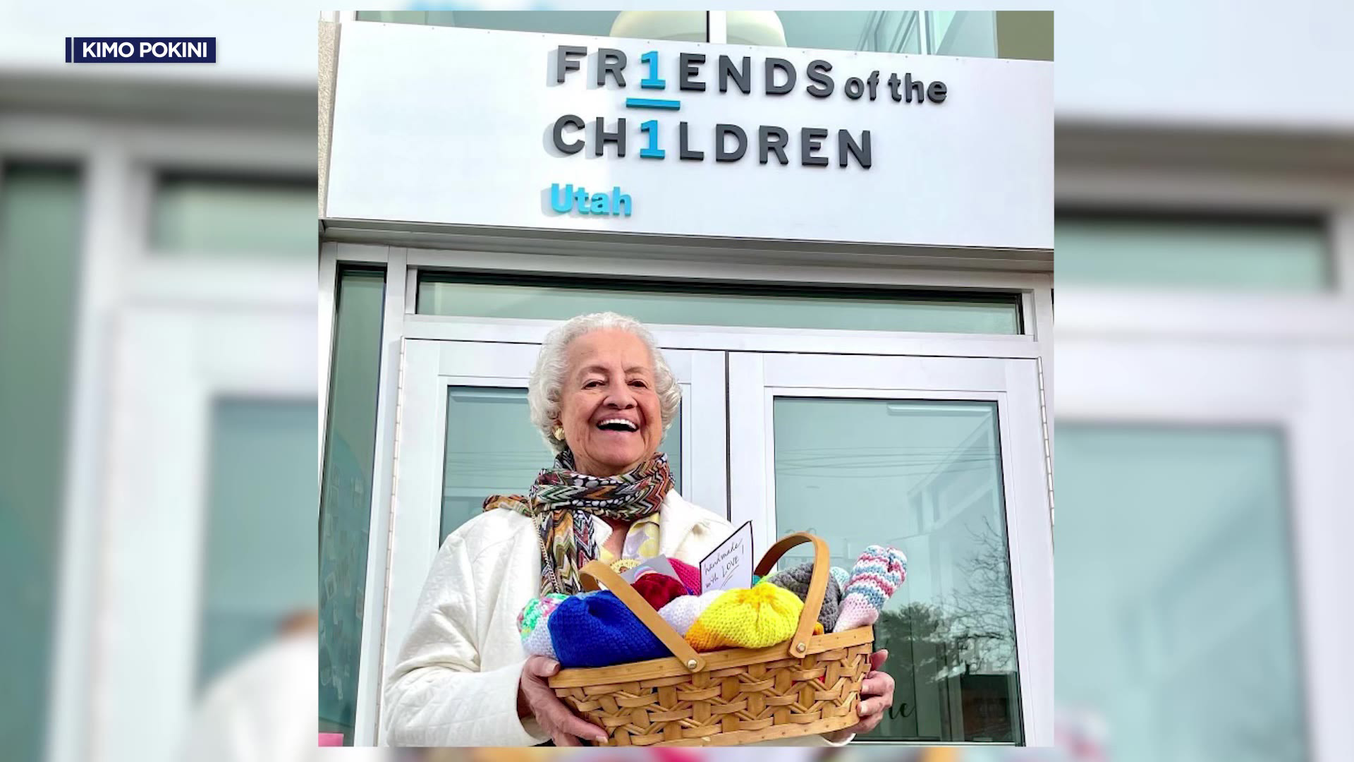 Rose is holding a basket of crochet creations in front of a childrens hospital....