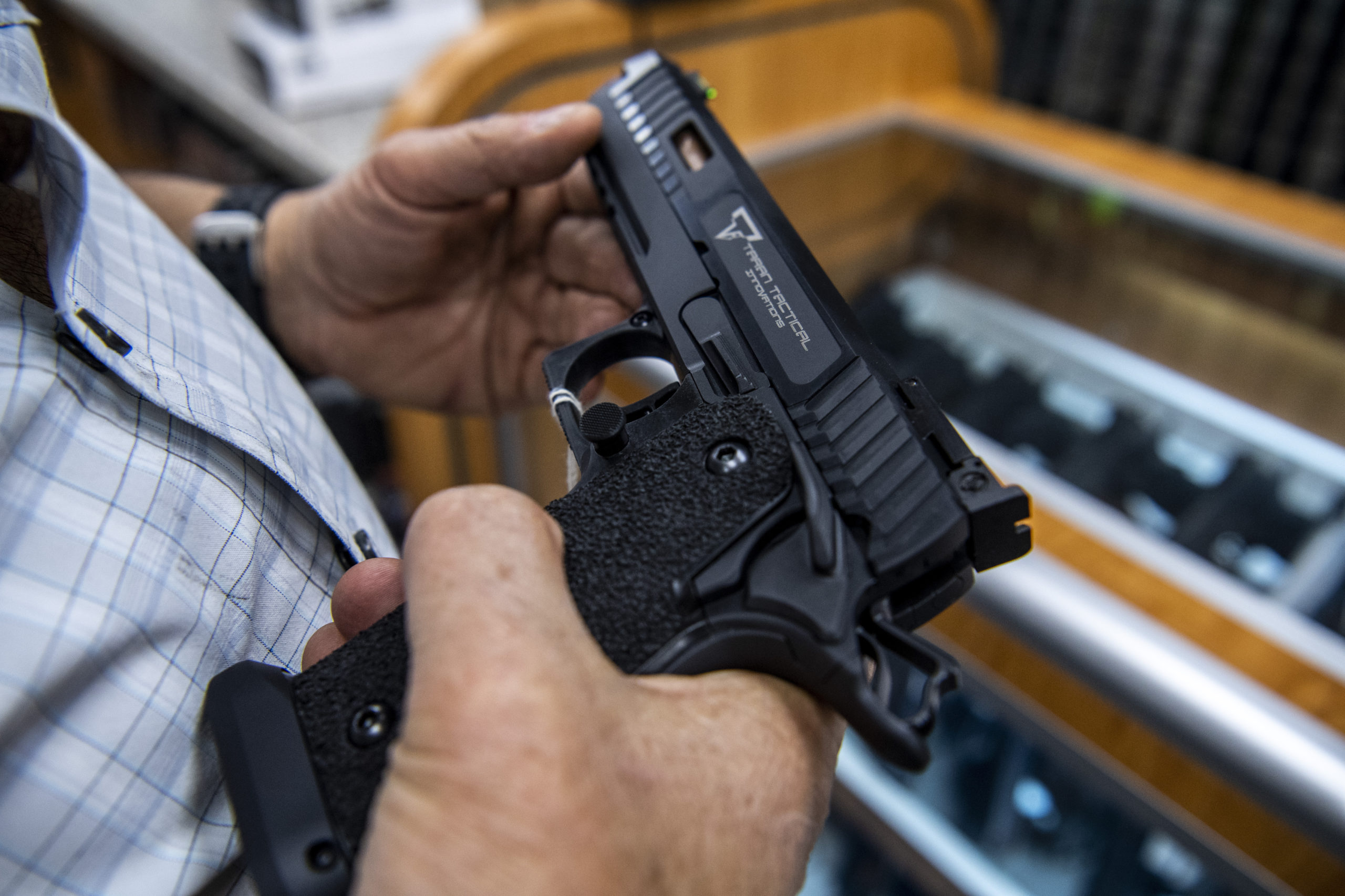 FILE - A customer checks out a hand gun that is for sale and on display at SP firearms on June 23, ...