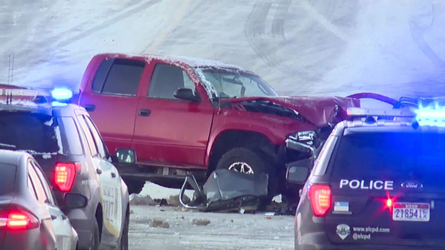 A truck is damaged after it crashed into another car in the snow....