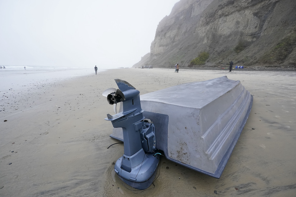 A boat sits overturned on Blacks Beach, Sunday, March 12, 2023, in San Diego. (AP Photo/Gregory Bul...