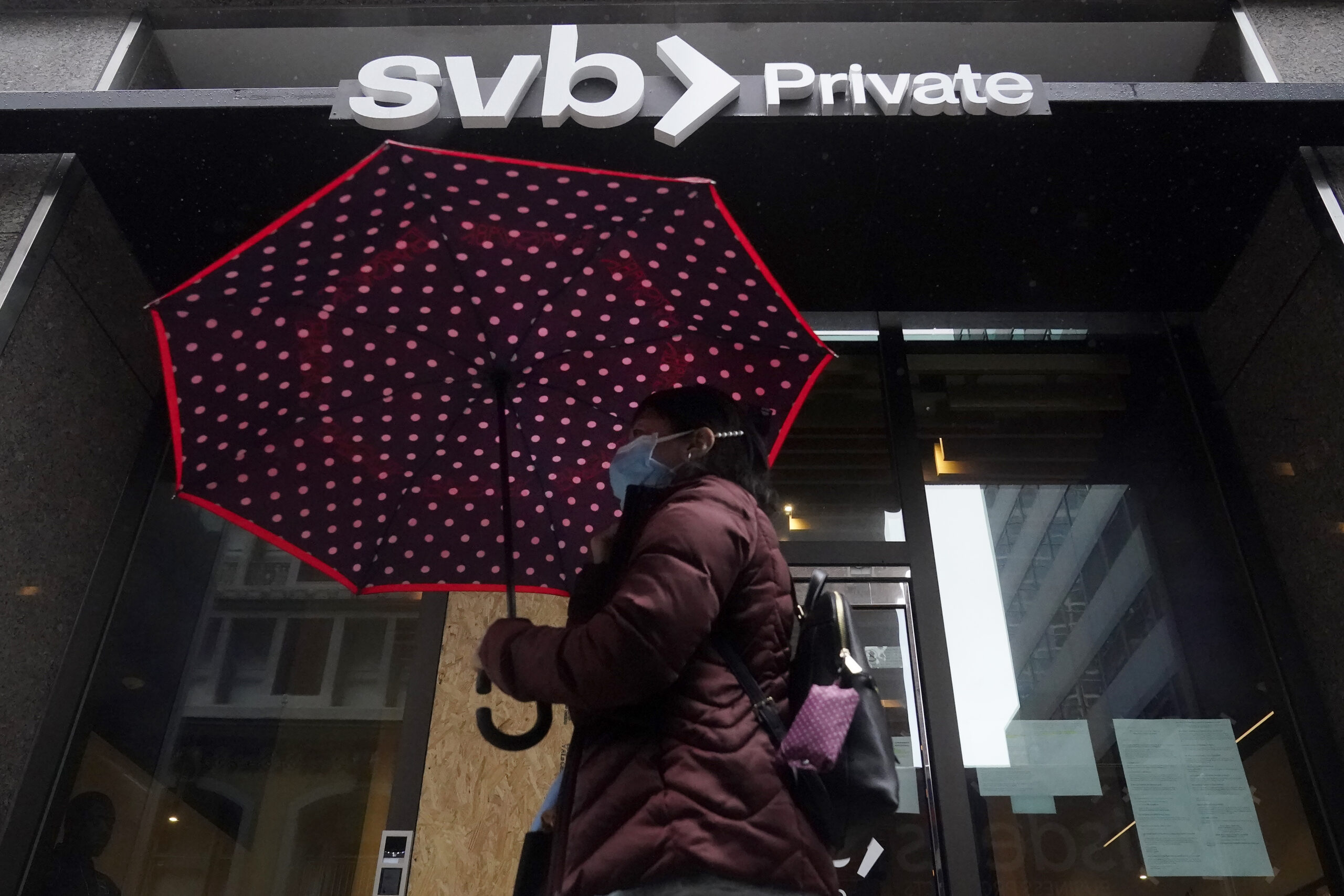A pedestrian carries an umbrella while walking past a Silicon Valley Bank Private branch in San Fra...
